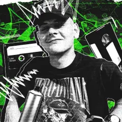 Młody raper z Krakowa, w czapce i z puszką sprayu, na tle kaset VHS i magnetofonowych.