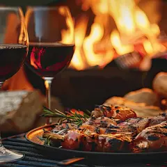 Dwa kieliszki czerwonego wina i talerz grillowanego mięsa przy ogniu. Idealne połączenie, by zastanowić się, jakie wino do grilla wybrać.