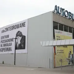 Budynek dworca autobusowego z banerem "zdeZINTEGROWANE CENTRUM PRZESIADKOWE IM. MIKOŁAJA KOPERNIKA".