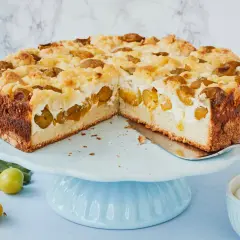Saftiger Mirabellenkuchen mit Quark und Streuseln auf einem blauen Tortenständer.