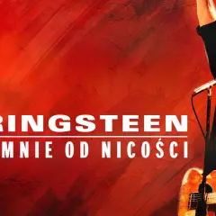 Bruce Springsteen na tle czerwonej ściany, z gitarą i mikrofonem. Napis "Springsteen Ocal mnie od nicości" sugeruje jego koncert w Polsce.