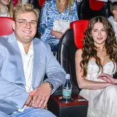 Roksana Węgiel i jej mąż, Kevin Mglej, siedzą w kinie. Ona w białej sukni, on w błękitnej marynarce.