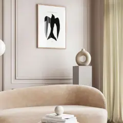 Ein gemütliches Wohnzimmer in greige farbe mit einem geschwungenen Sofa, einem modernen Stehlampen und einem Kunstwerk mit einem Vogel.