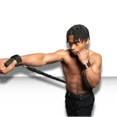 A boxer trains to punch faster using resistance bands attached to his wrists, building explosive power.