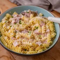 Fusilli-Nudeln in cremiger Schinken-Sahne-Sauce, garniert mit Petersilie. Ein köstliches Gericht, das zum Genießen einlädt.