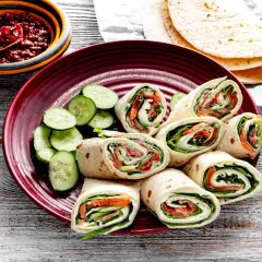 Pyszna tortilla z łososiem, serkiem i świeżym ogórkiem, podana z pikantnym sosem. Idealna na szybki lunch.