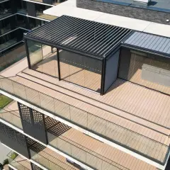 Nowoczesny taras na dachu z przeszklonym pawilonem i pergolą. Drewniana podłoga i szklane balustrady tworzą elegancką przestrzeń.