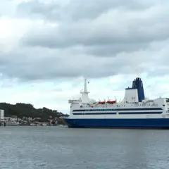 Duży prom pasażerski, podobny do tych kursujących na trasie Dover, zacumowany przy brzegu.