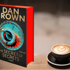 Dan Browns "The Secret of Secrets" Thriller neben einer Kaffeetasse. Robert Langdon würde dieses Rätsel lieben.