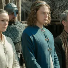 Obsada "Upadek Królestwa" w historycznych strojach: młody książę, kobieta z krzyżem i starszy mężczyzna.