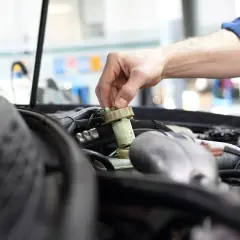 Mechanik sprawdza płyn hamulcowy, by uniknąć kary za spóźniony przegląd.