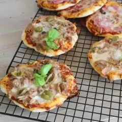 Mini pizze z tuńczykiem, oliwkami i bazylią na ruszcie. Idealne na szybką przekąskę.