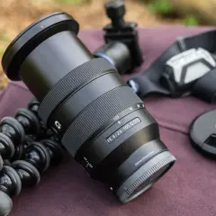 Obiektyw Sony FE 4/24-105 G OSS, idealny do krajobrazu, leży obok statywu i akcesoriów.