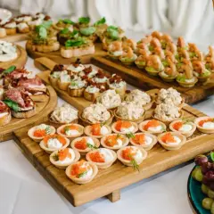 Vielfältige Snacks zum Aperitif: Bruschetta mit Salami, Käseplatte, Garnelen-Häppchen und süße Törtchen mit Kaviar.