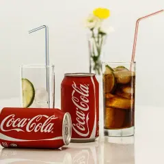Puszki i szklanki z Coca-Colą, lodem i limonką. Zastanawiasz się, ile kalorii ma Coca-Cola?