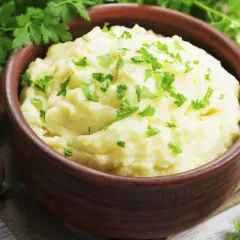 Un cremoso puré de patatas, un acompañamiento perfecto, adornado con perejil fresco.