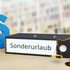Ein Ordner mit der Aufschrift "Sonderurlaub" neben Paragraphen-Symbolen und einer Waage. Erinnert an den Sonderurlaub bei Beerdigung der Oma.