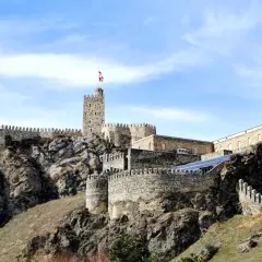 Kamienna twierdza na wzgórzu, dumnie górująca nad krajobrazem. To zamek Rabati w Achalciche, Gruzja, świadectwo historii i potęgi.