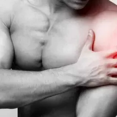 Un homme tient son épaule douloureuse, une longue portion de son bras est marquée en rouge pour indiquer la douleur.