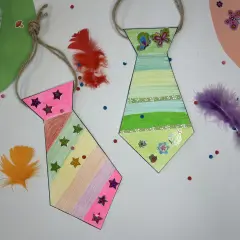Bunte Krawatten basteln mit Federn und Stickern. Eine pinke und eine grüne Krawatte, dekoriert mit Sternen und Schmetterlingen.