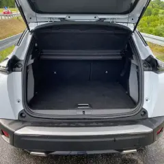 Otwarty bagażnik białego Peugeot 2008. Wymiary tego SUV-a pozwalają na wygodne pakowanie.