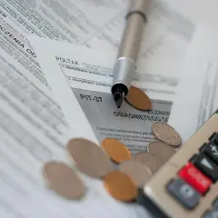 Druk PIT-37, długopis i monety. Czy budowę domu można odliczyć od podatku? Sprawdź na formularzu.
