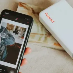 Jak wydrukować zdjęcie z telefonu? Smartfon z kotem i drukarka Polaroid w akcji.