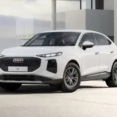 Białe Audi Q3 Sportback na tle nowoczesnego budynku.
