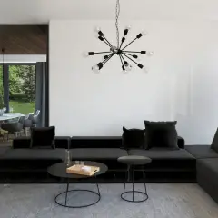 Nowoczesny salon z czarną sofą i designerskim oświetleniem. Sufit z belkami dodaje charakteru.
