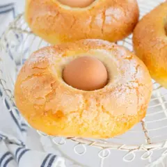 Monas de Pascua doradas y azucaradas, con un huevo cocido en el centro, listas para celebrar la primavera.