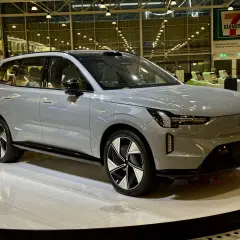 Grå Volvo EX90 på en utställningsplattform. Framtiden för volvo car mobility visas upp på flygplatsen.