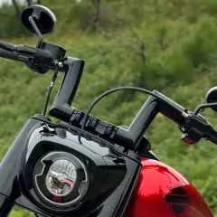 Manubrio drag bar Harley nero lucido, con specchietti e faro tondo.