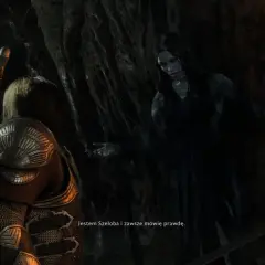 Szeloba, widmowa postać z gry Shadow of War, przemawia do bohatera w mrocznej jaskini.