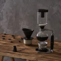 Kawiarka syfonowa i dripper na drewnianym blacie. Dowiedz się, jak długo parzyć kawę sypaną, by uzyskać idealny smak.