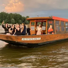 Grupa kobiet świętuje na łodzi przy dworcu wodnym WWA. Zachód słońca nad Wisłą.