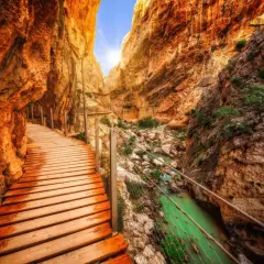 Chemin de bois longeant une gorge spectaculaire en Espagne, avec une rivière émeraude en contrebas. Un trek inoubliable.
