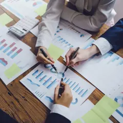 Zespół analizuje wykresy i dane, tworząc strategię sprzedaży. Wzór sukcesu tkwi w szczegółach.