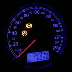 Tablero de coche con luces de advertencia de ABS y fallo encendidas. El velocímetro muestra 0 km/h.