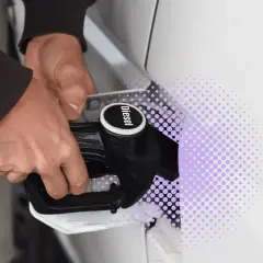 Mano che inserisce la pompa diesel nel serbatoio di un'auto con motore Euro 5.