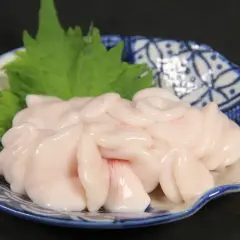 Delicato lattume di tonno servito su un piatto decorato con un rametto verde.