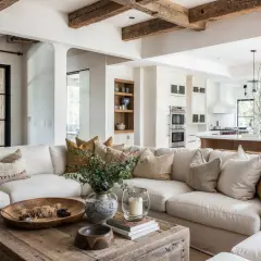 A cozy living room showcasing types of rustic interior design, featuring exposed wooden beams, a distressed coffee table, and textured neutral furnishings.