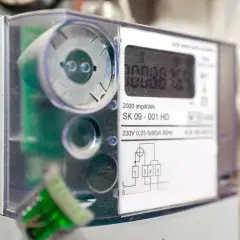Cyfrowy licznik energii elektrycznej z widocznym wyświetlaczem i schematem podłączenia.
