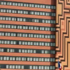 Façade d'un hôtel orange avec des motifs géométriques et des fenêtres.