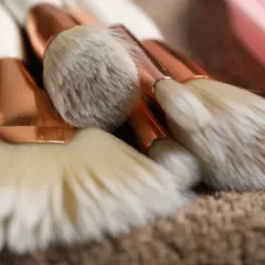 Set de brochas de maquillaje con mangos blancos y detalles dorados, listas para aprender como limpiar brochas de maquillaje.