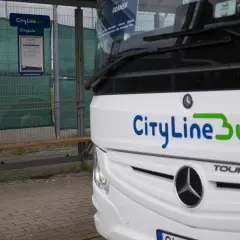 Autobus CityLineBus czeka na pasażerów na przystanku. Może to być podróż z Kielc na lotnisko w Katowicach.
