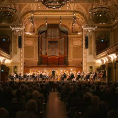 Ein Orchester spielt im prunkvollen Saal des Opernhauses Wuppertal vor einem begeisterten Publikum.