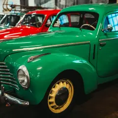 Rząd zielonych i czerwonych, **stare samochody polskie** lśnią w garażu. Klasyki z PRL-u czekają na przejażdżkę.
