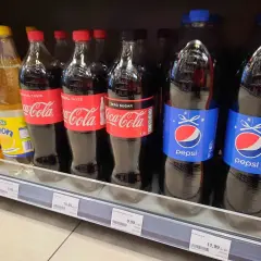 Butelki Pepsi i Coca-Coli na półce sklepowej. Cena Pepsi 2L to 11,99 zł.