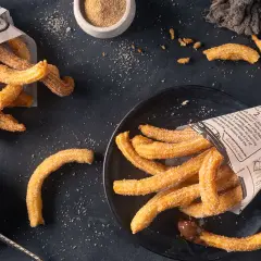 Frisch frittierte Churros, mit Zucker bestreut, serviert mit Schokoladensauce. Perfekt zum Churros selber machen!