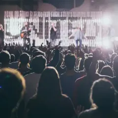 Koncert, tłum z rękami w górze. Na scenie zespół, wokalistka zachwyca sopran głosem.